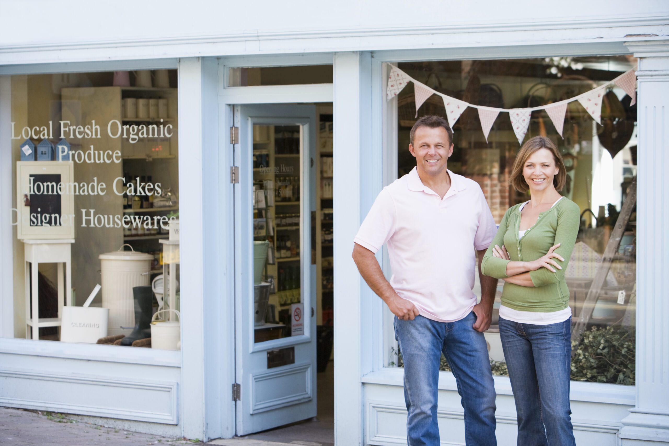 Couples Standing In Front Of Organic Food Store Smiling